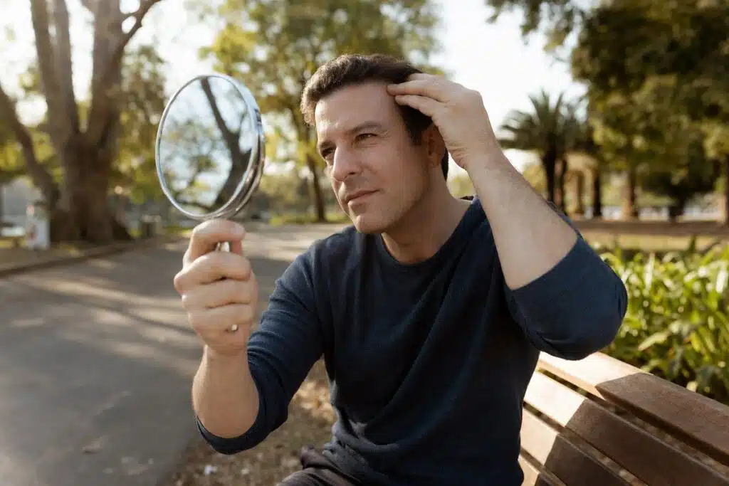 Man checking Botox results on forehead in mirror at Miami Lakes park