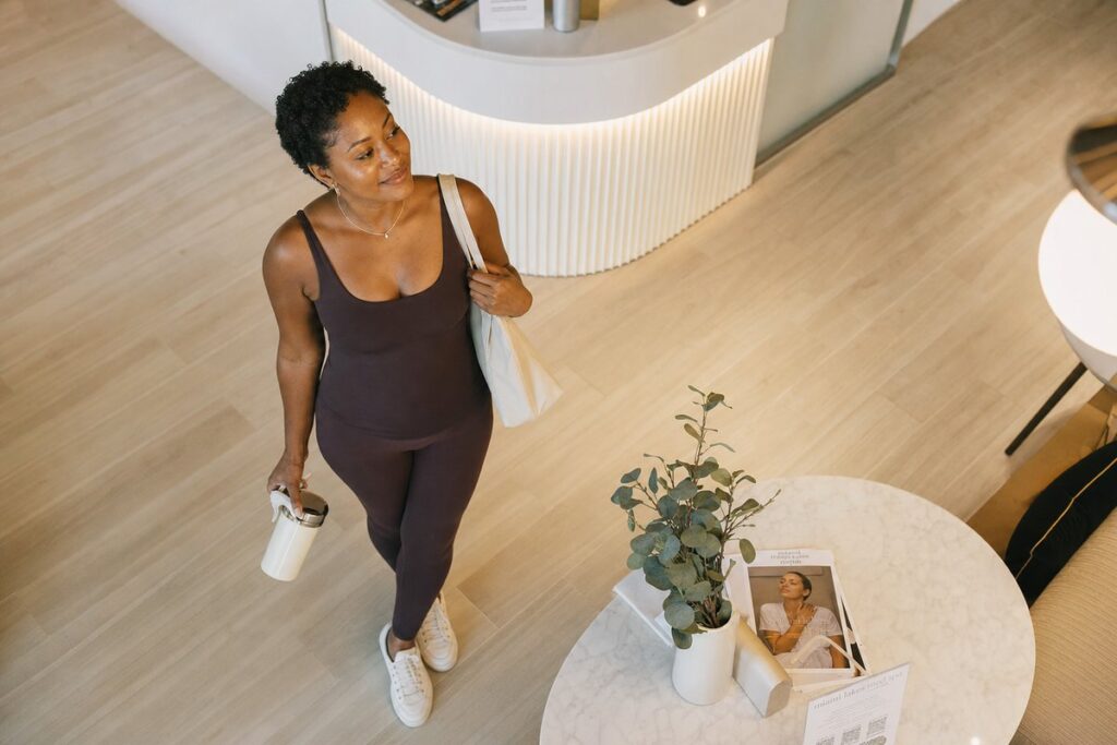 Black woman with clear glowing skin in boutique gym lobby after VI Peel acne treatment at Miami Lakes Med Spa