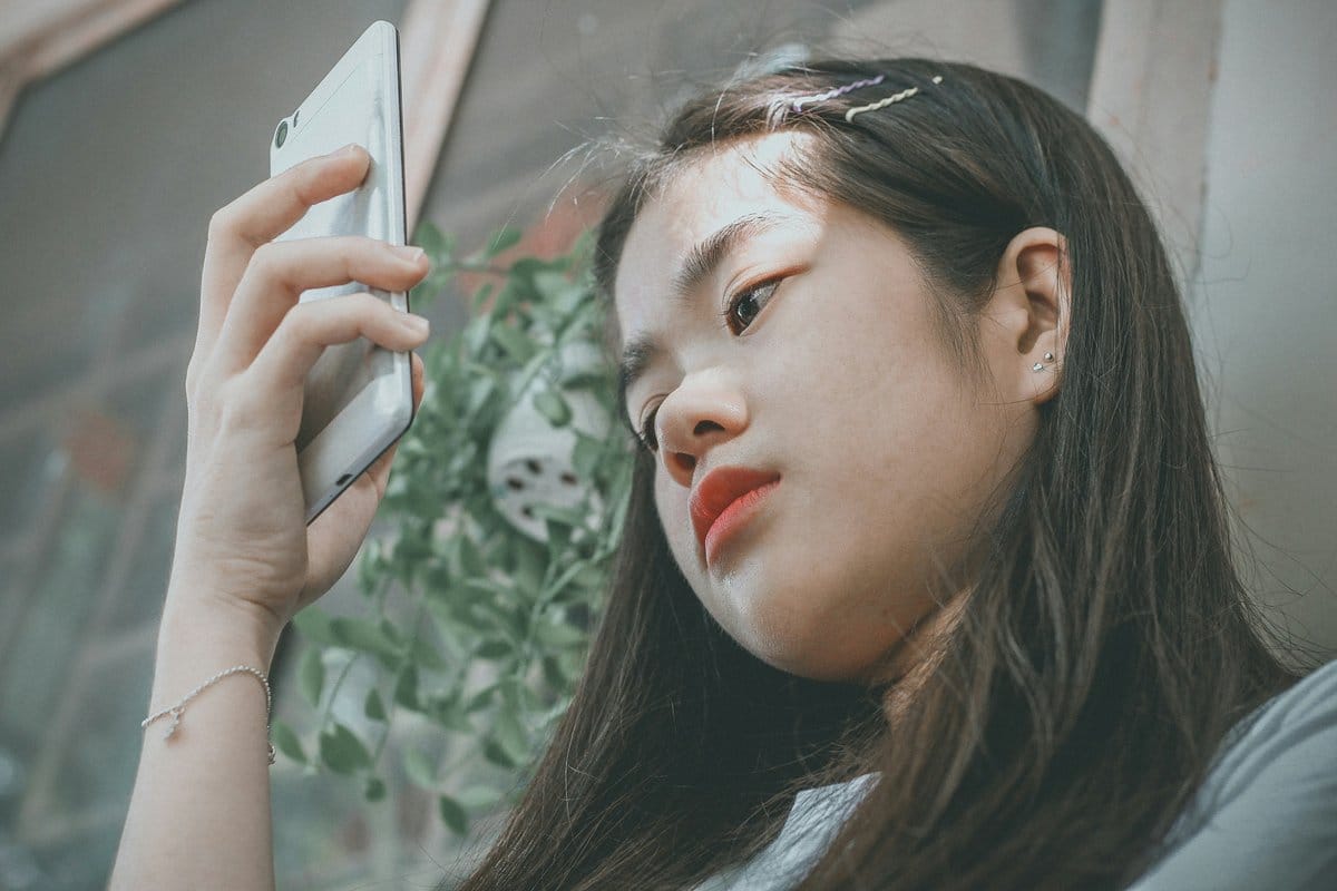 Young woman taking a selfie showing her smooth forehead and natural Botox results after treatment
