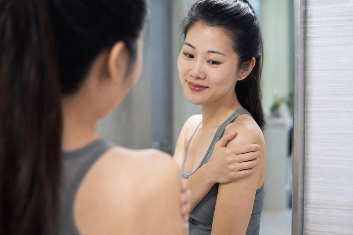 Woman testing her healed shoulder range of motion after PRP upper extremity treatment