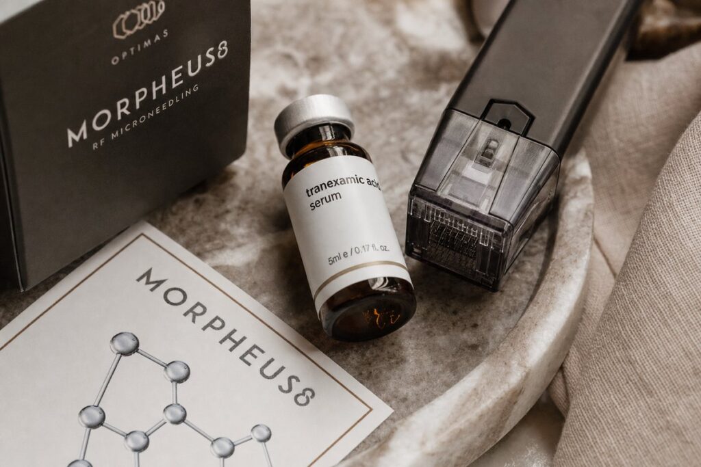 Morpheus8 RF microneedling handpiece and tranexamic acid serum vial on marble tray at Miami Lakes Med Spa