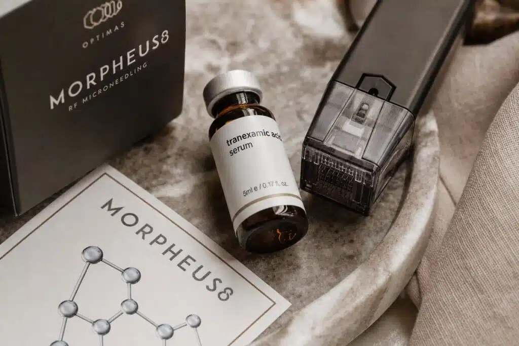 Morpheus8 RF microneedling handpiece and tranexamic acid serum vial on marble tray at Miami Lakes Med Spa