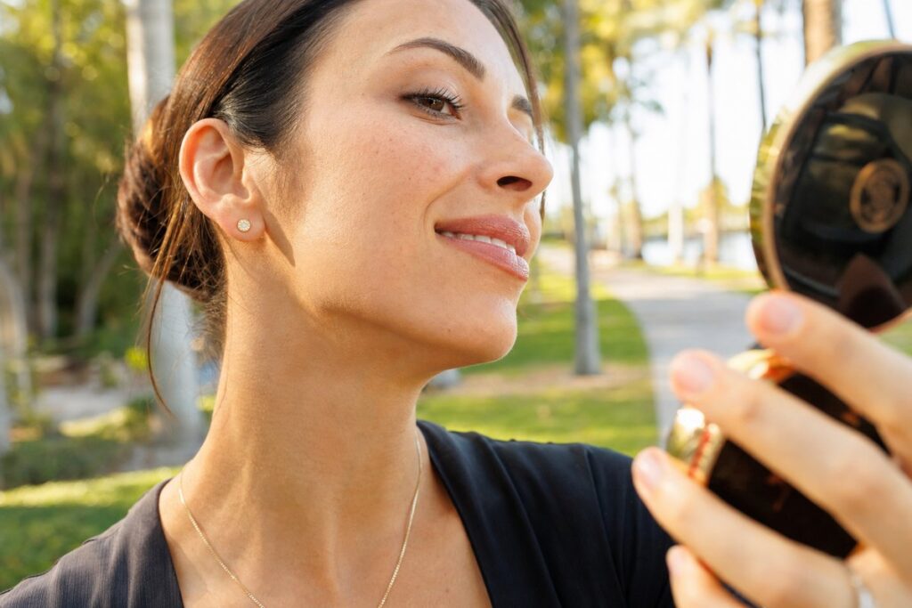 Woman in her 30s checking her tightened jawline result after Morpheus8 RF microneedling at Miami Lakes Med Spa