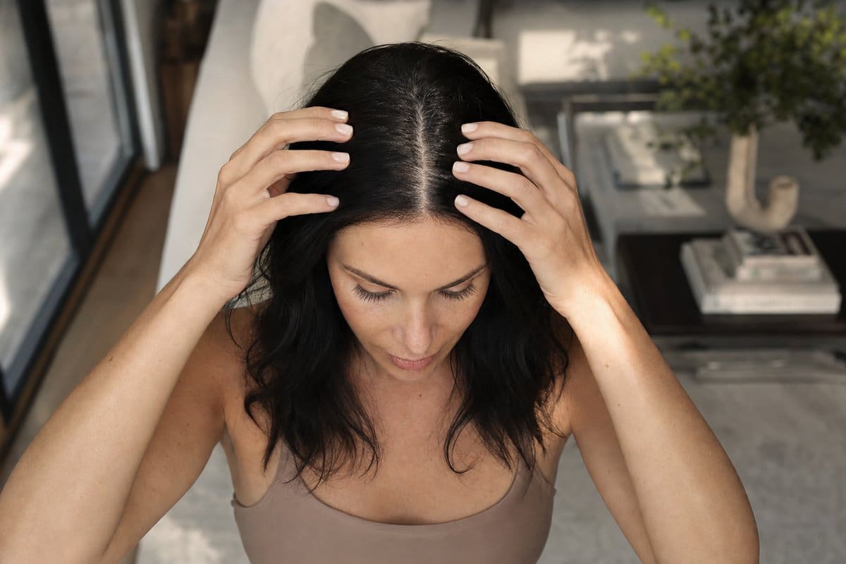 Close-up of a woman's center part showing thick, dense hair after female hair thinning treatment at Miami Lakes Med Spa
