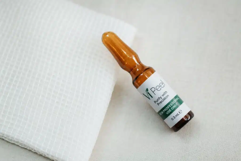 VI Peel ampoule and gauze pad flat lay on linen showing chemical peel product safety and quality